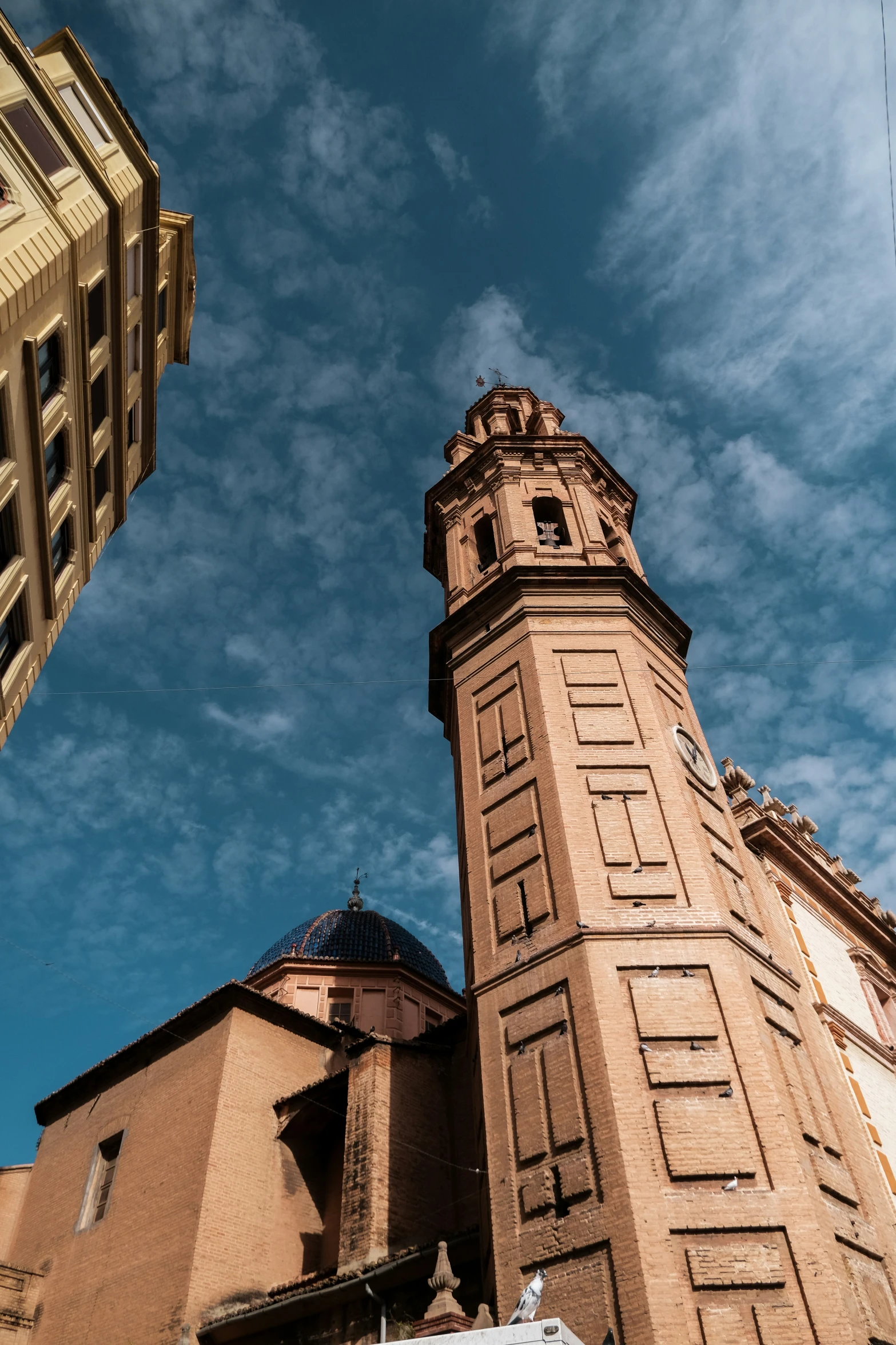 large red brick building next to tall tan building