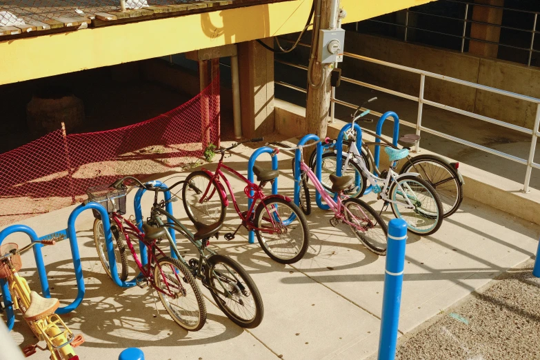 a row of bikes is parked on the curb