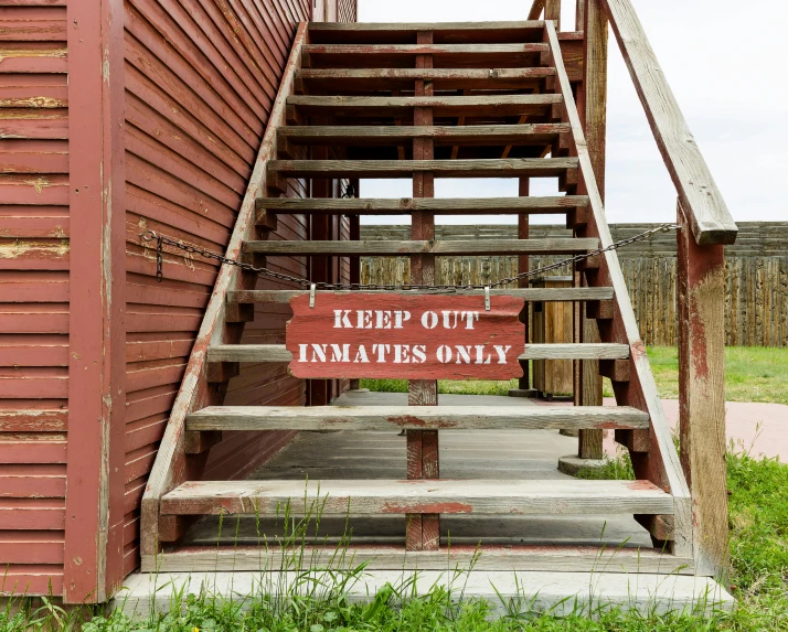 some wooden stairs and a red building with a sign