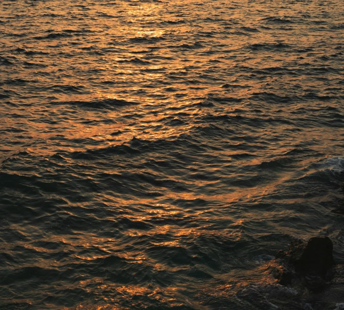 an ocean scene with a sun rising over the horizon