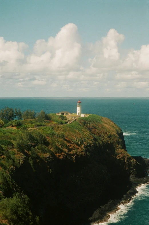 a white lighthouse on a cliff overlooking the ocean