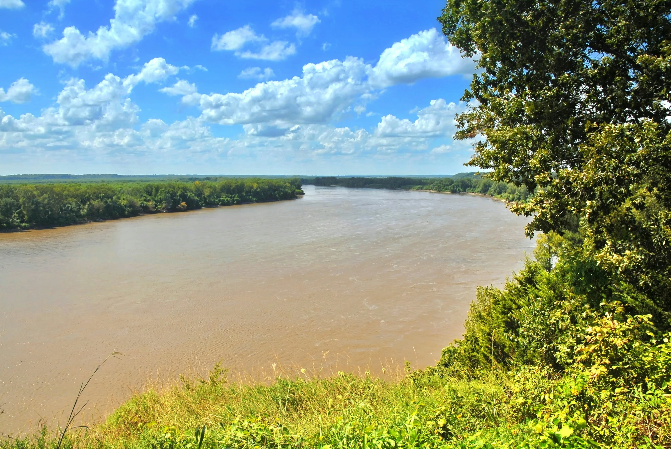 the view from a hill that looks to be on the river