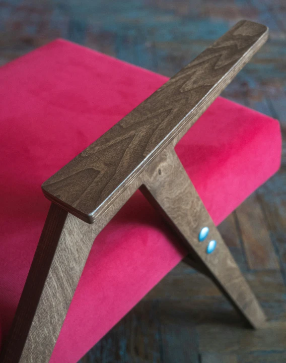 wooden cross is sitting on top of a pink material