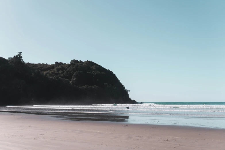 people are playing in the ocean waves at a beach