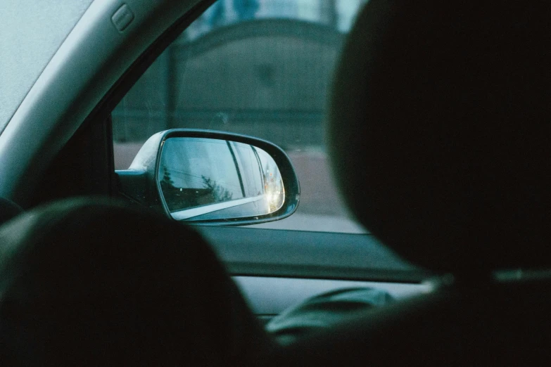 a car's side view mirror with its reflection being reflected in it