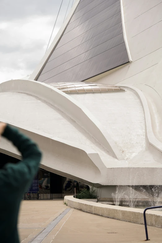 a person taking a picture in front of a big building