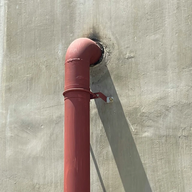 an image of a red pipe on the side of a building