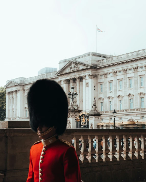 a close up of a person dressed in uniform with the palace behind them