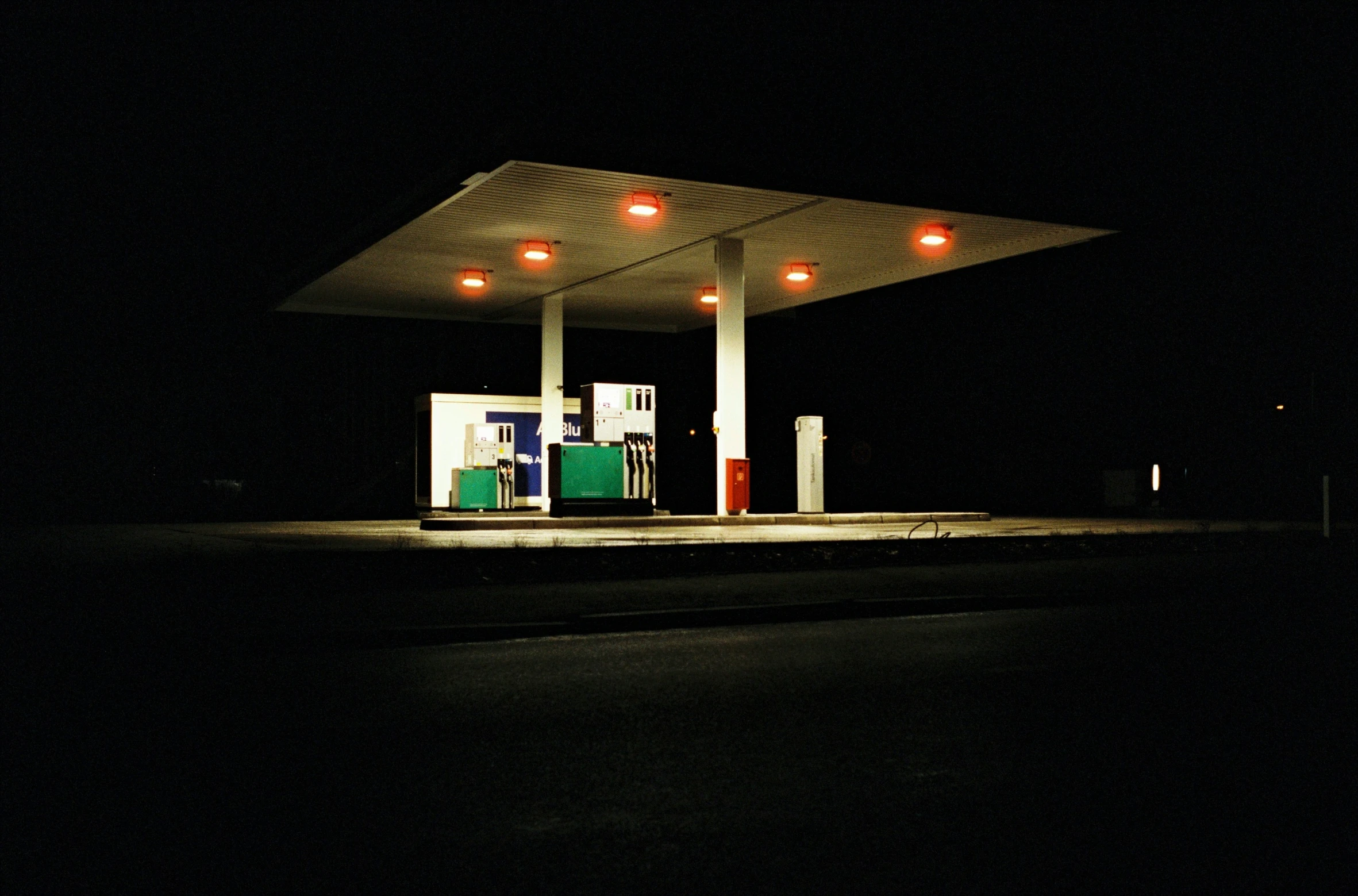 a gas station with its lights on during the evening