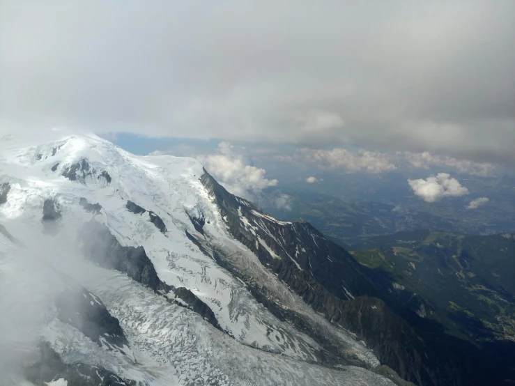 snowy mountains with clouds flying in the sky