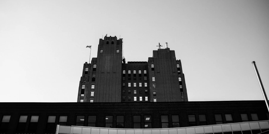 the large building is very tall and grey with windows