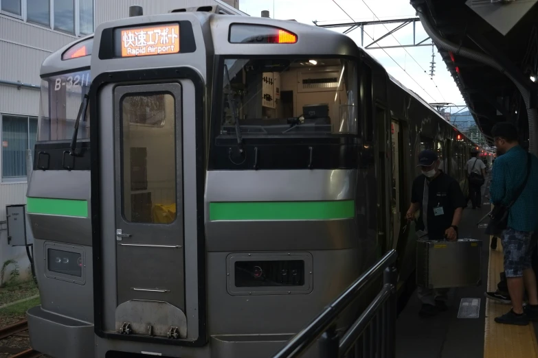 people walk near a subway train at a station