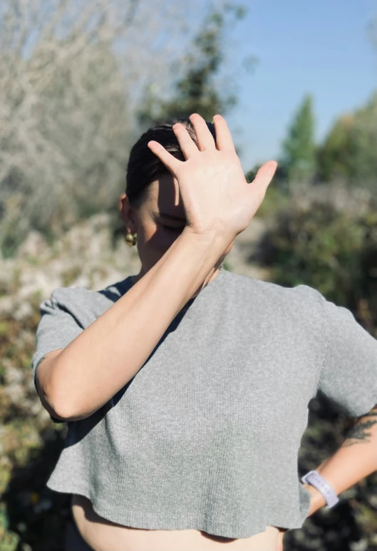 woman with back to camera holding arm over head