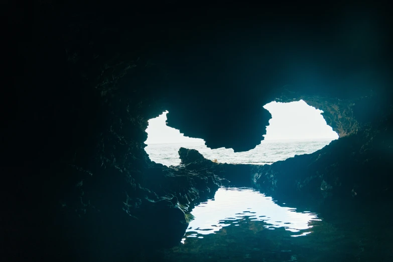 the light is reflected in the water at the edge of the cave