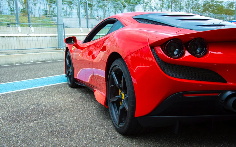 the rear end of a red sports car on a highway