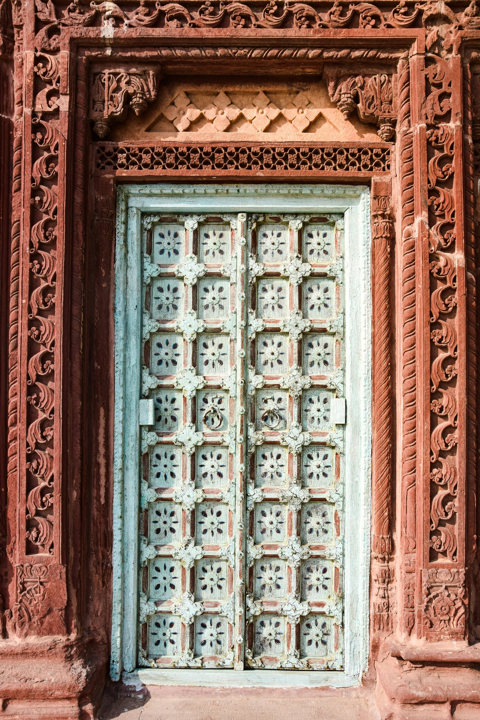 two doors are seen in front of an orange building