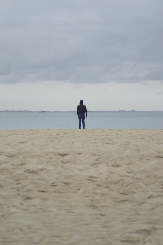 a man on the beach looking at the ocean