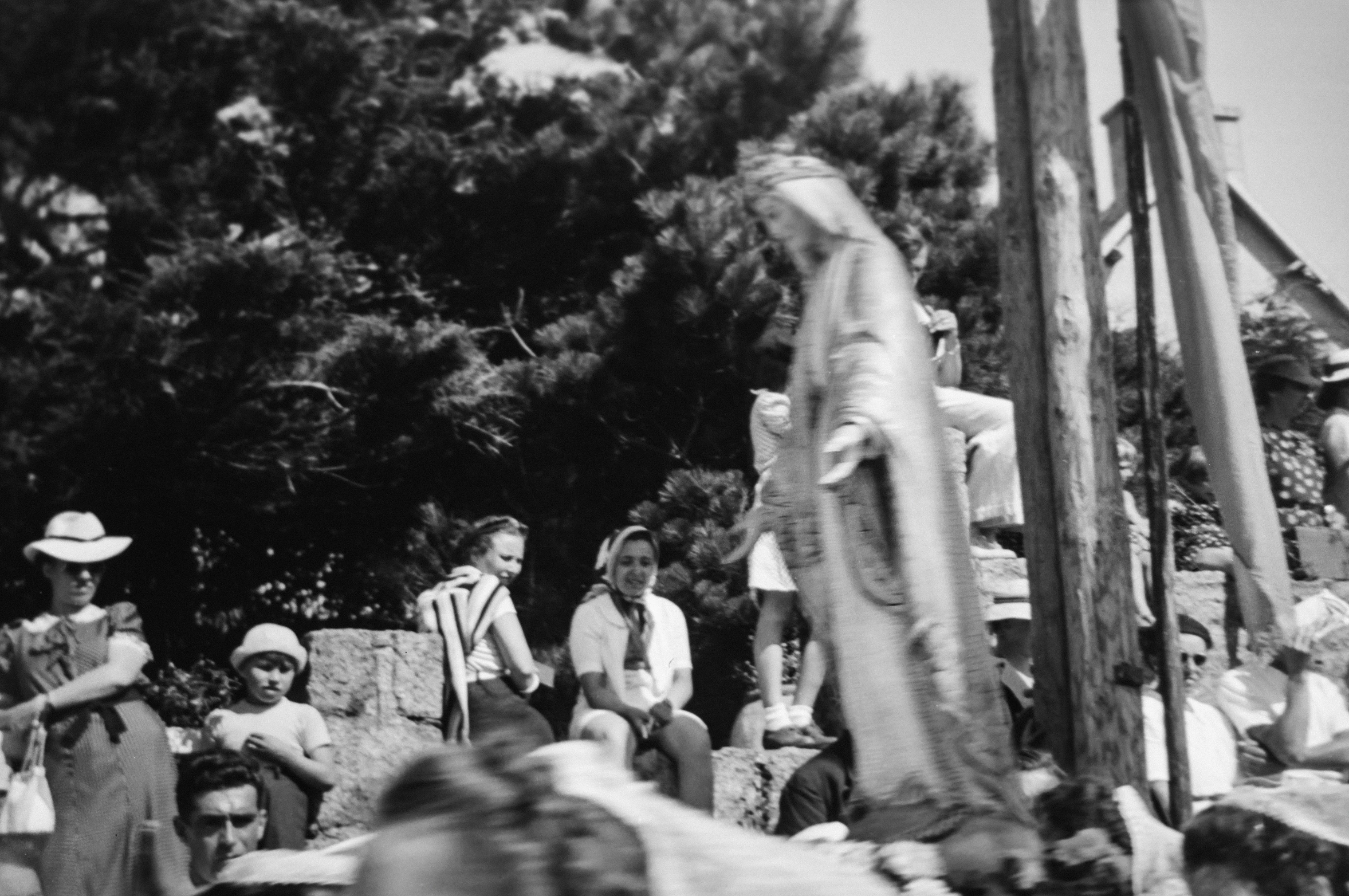 a large group of people sitting and standing around a statue