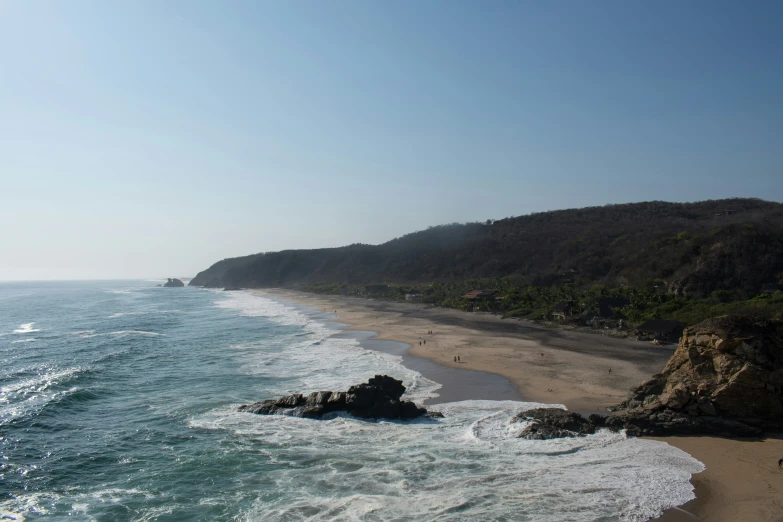 a beach near the ocean with waves crashing on the sand