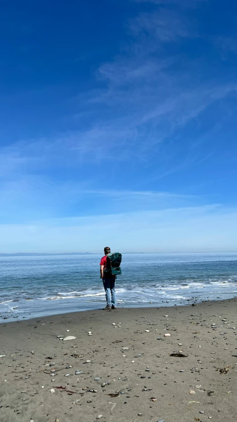 a person walking across a beach near the water