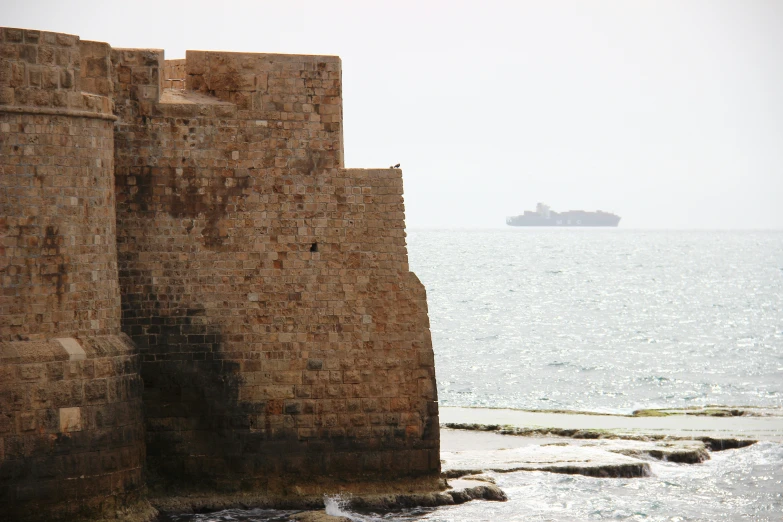 a large brick wall next to a body of water