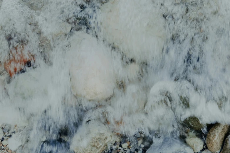 some ice on rocks are flowing water