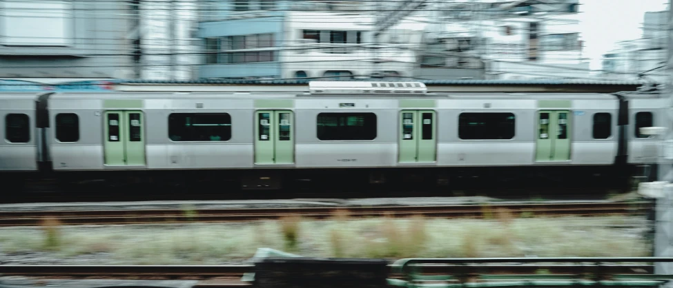 a train on train tracks next to building with large windows