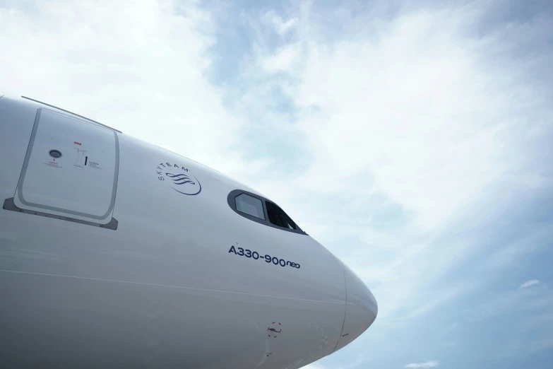 closeup on the side of a plane that has a sky in background