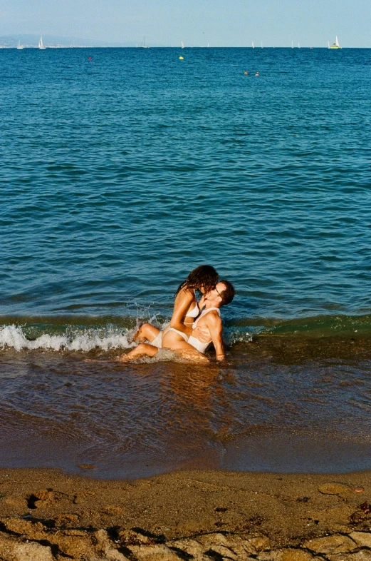 two women in a body of water lying back to each other