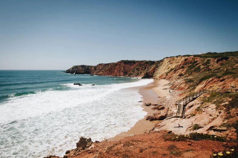 a beach is next to a steep cliff