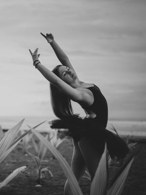 black and white po of a woman reaching up to sky