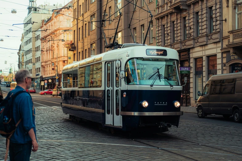 a man walking down a brick street next to a trolley