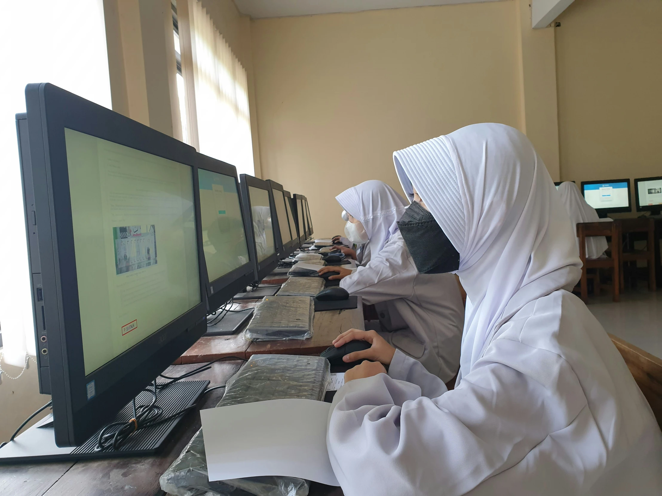 two people sitting at a desk on computers