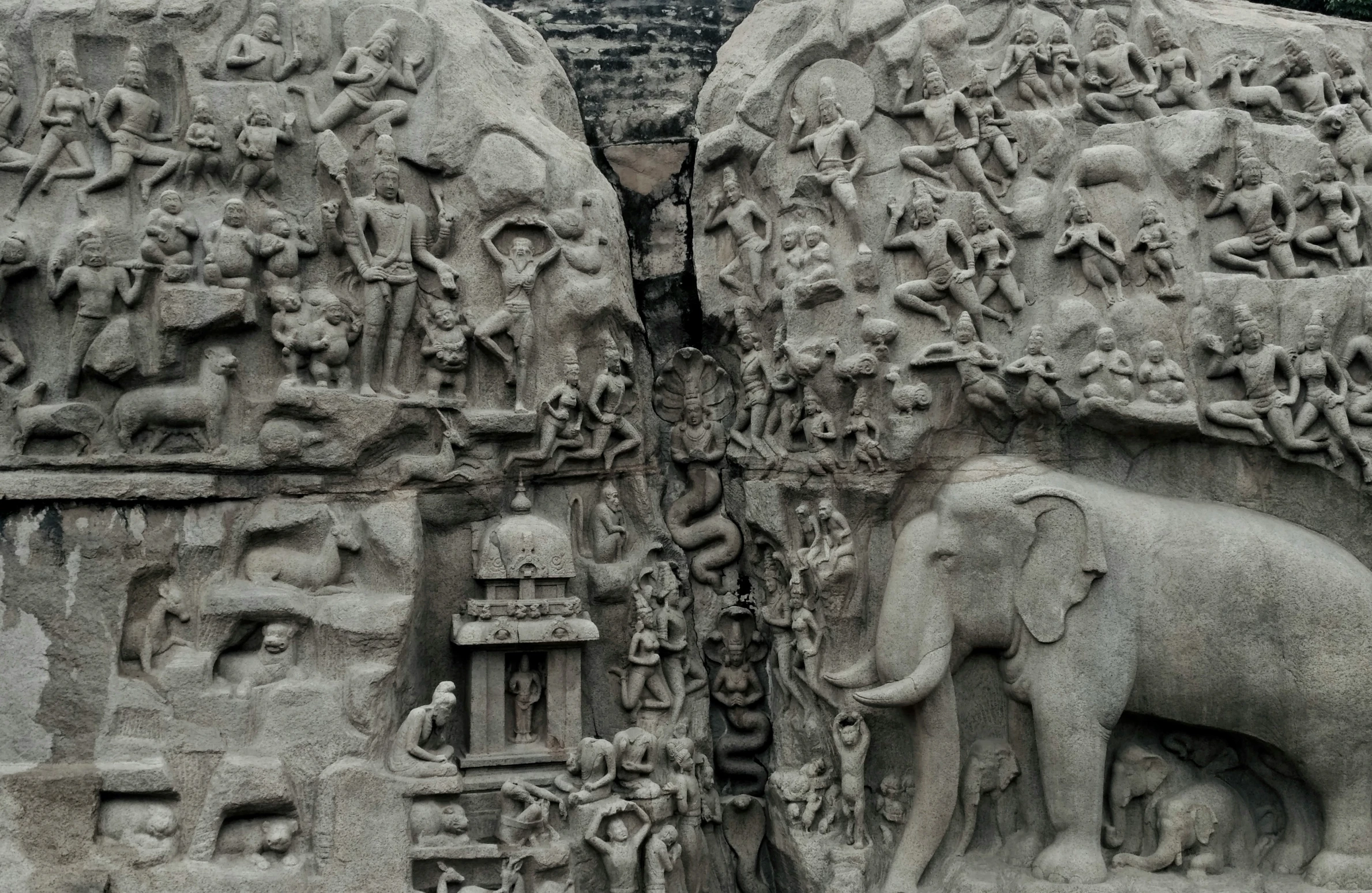 an elephant sculpture is next to an elephant with several small heads