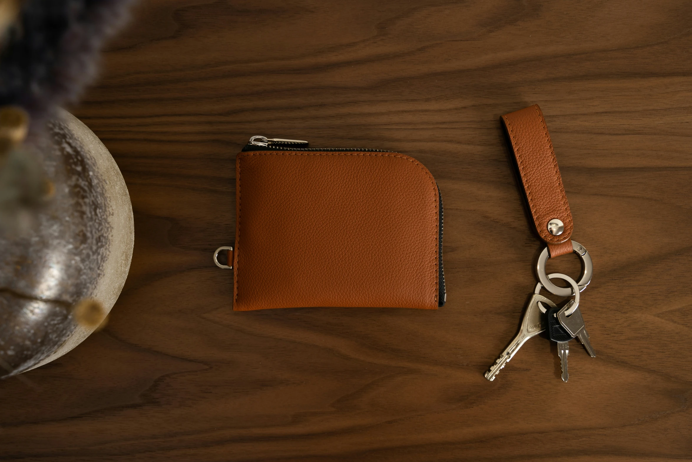 a small wallet and pair of scissors on a wooden table