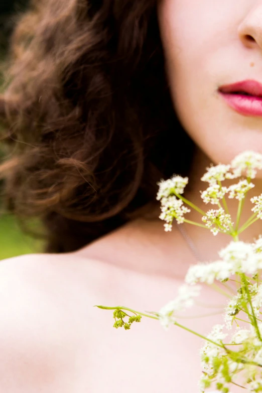 a girl is standing by flowers looking at the camera