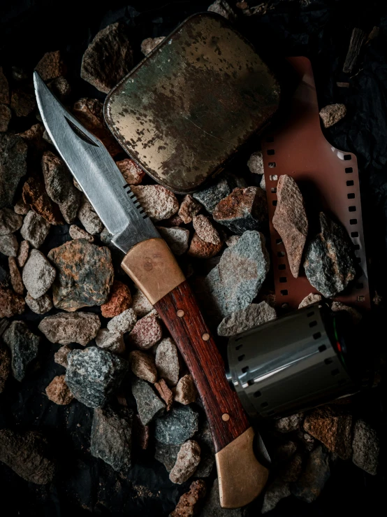 a metal knife and some rocks on a black background