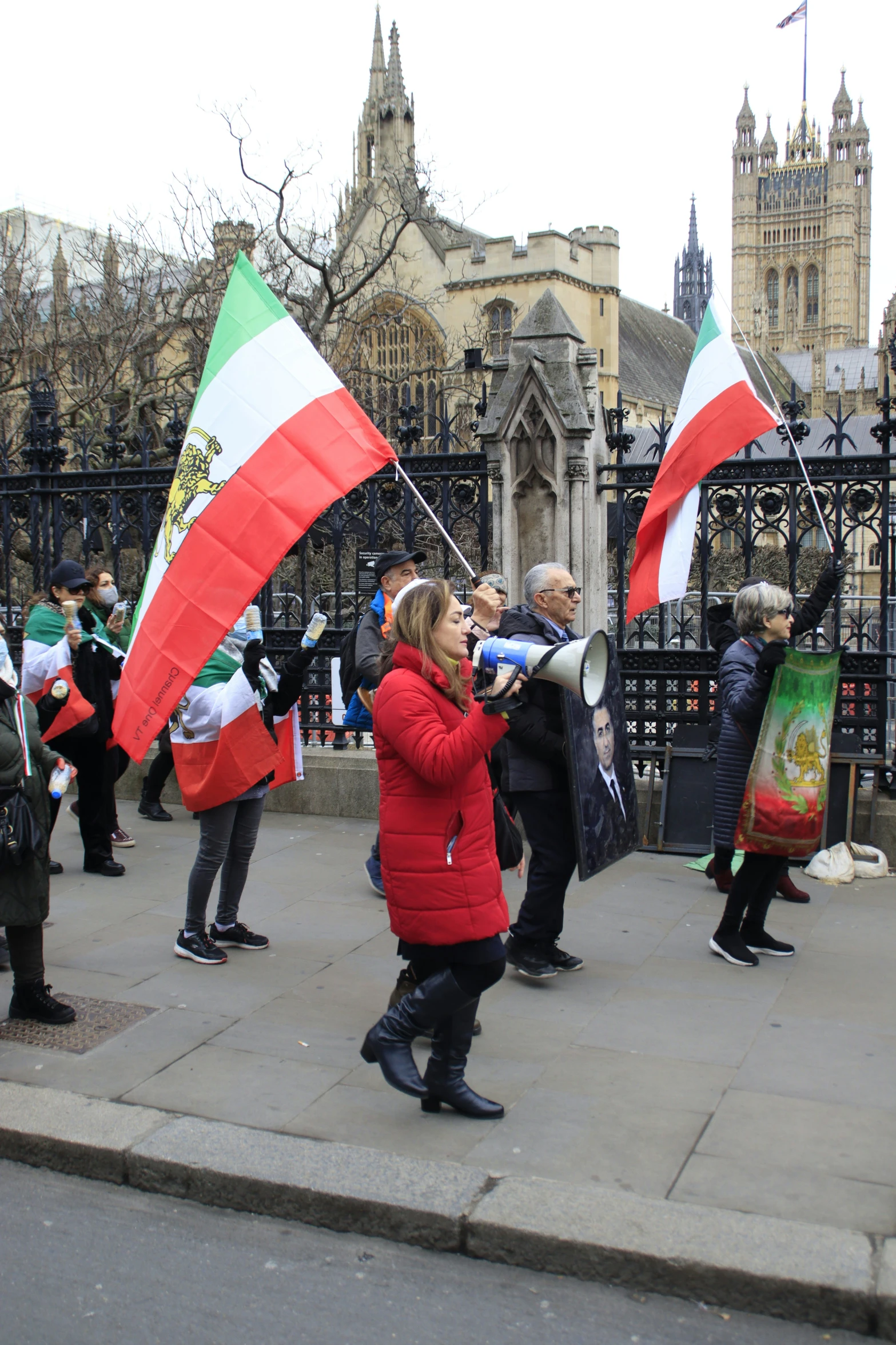 people walking on a sidewalk holding flags in the shape of the flag