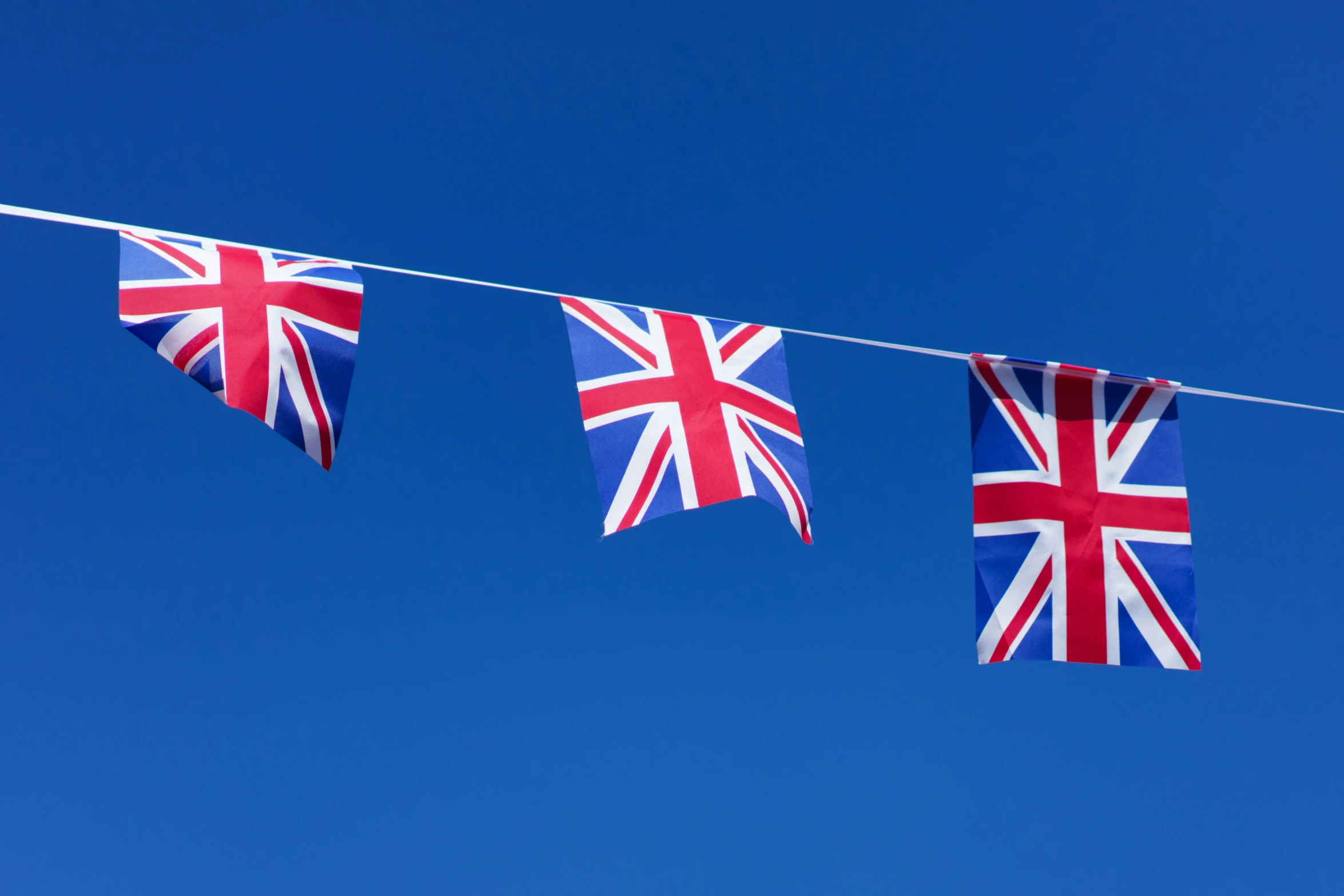 three british flags that are hanging from a string