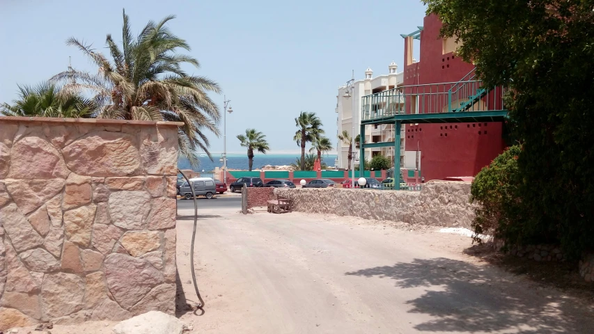 a quiet road on the beach with cars parked