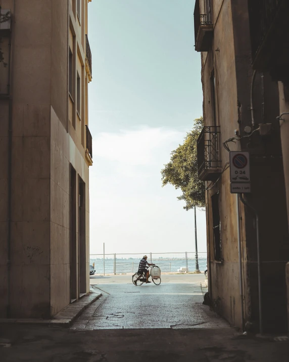 motorbike rider passing through narrow alleyway in urban setting