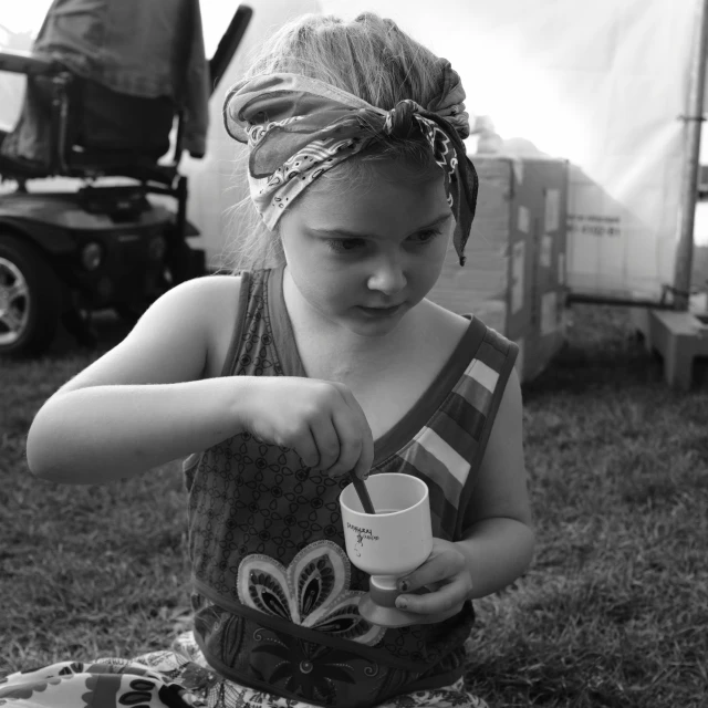 a little girl holding onto some coffee cup