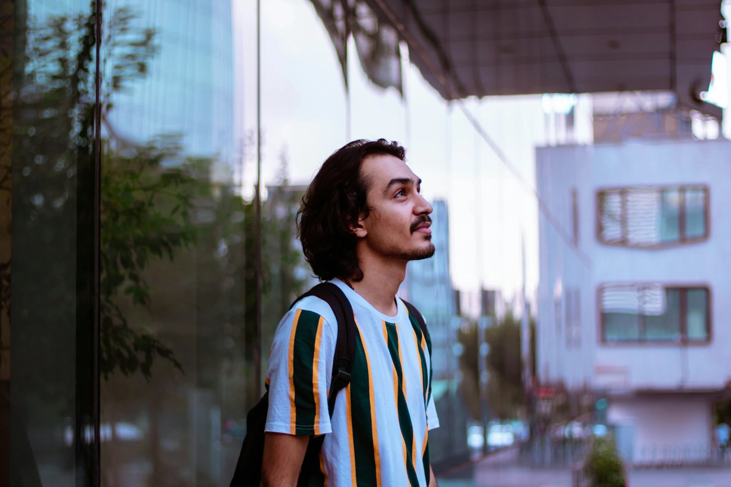 a man standing on the side of a road next to tall buildings