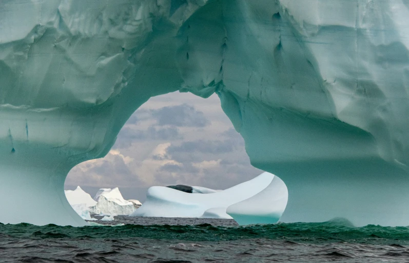 an iceberg in the ocean, with two rocks and ice