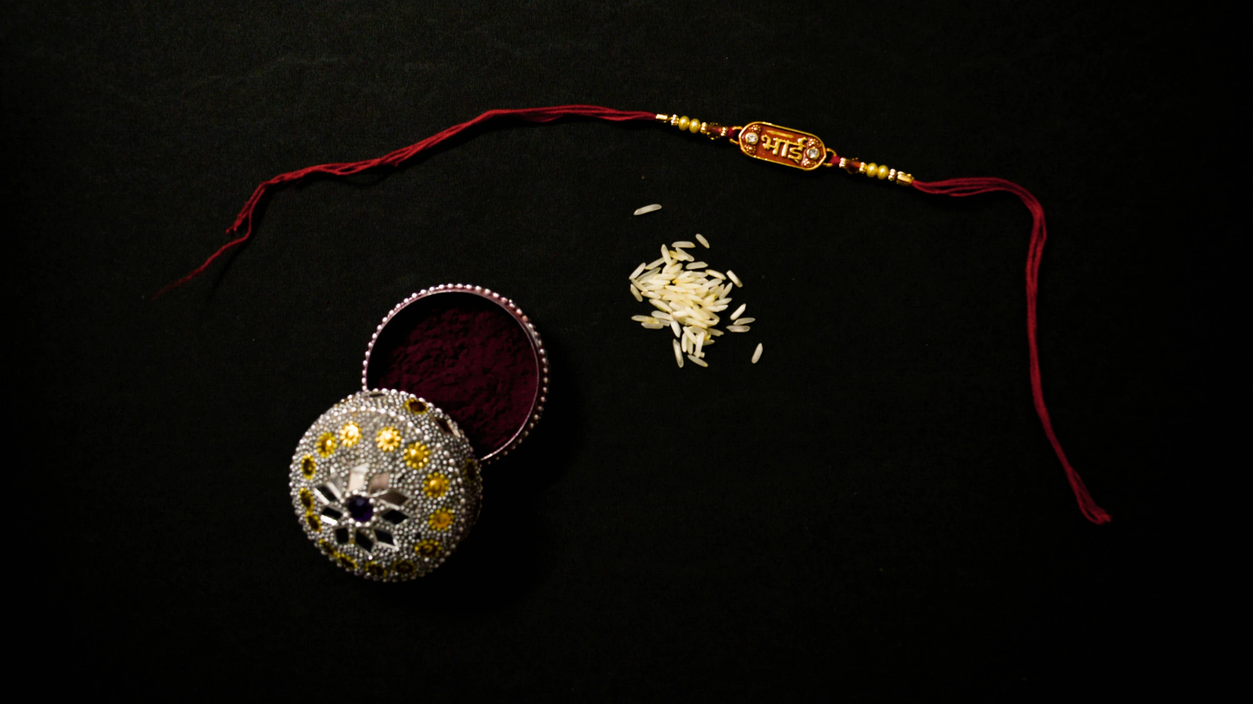 two white and gold indian artifacts laying on a black surface