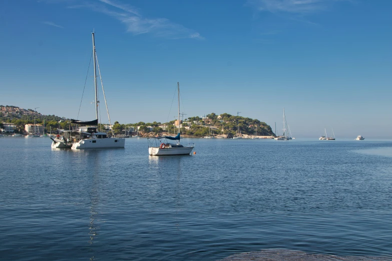 small boats are sitting on the water at the edge of a hill