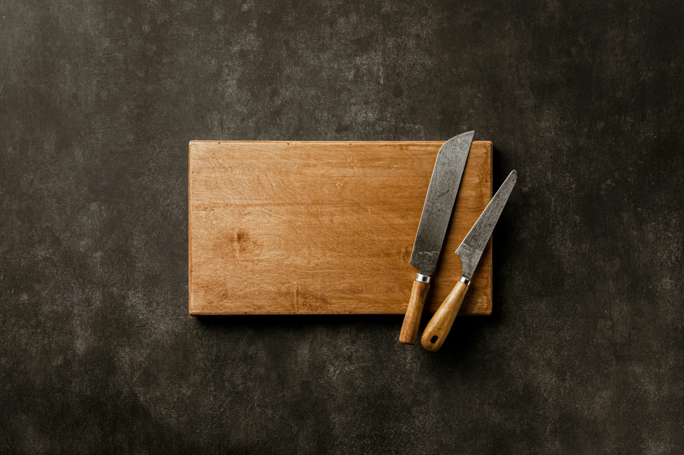 a chopping board and two knives on it