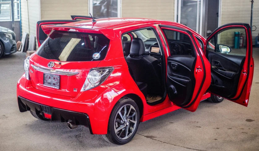 a bright red smart car has the door open and the interior is trimmed