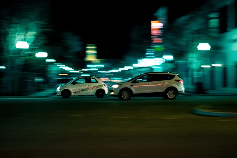 two cars stopped in front of a large building on a street