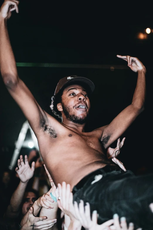 a man wearing a hat standing in front of a crowd